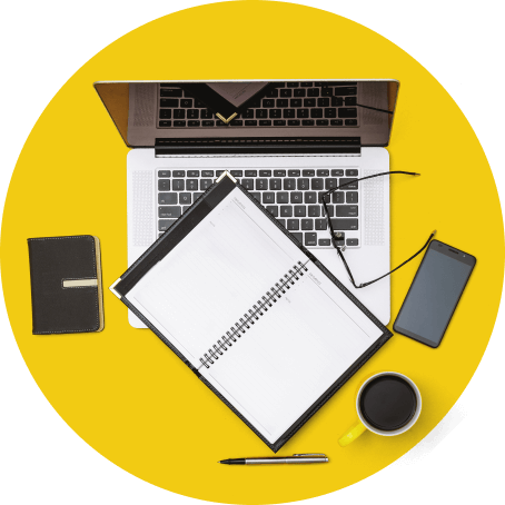 Two notepads, a MacBook, cell phone & coffee on a yellow table